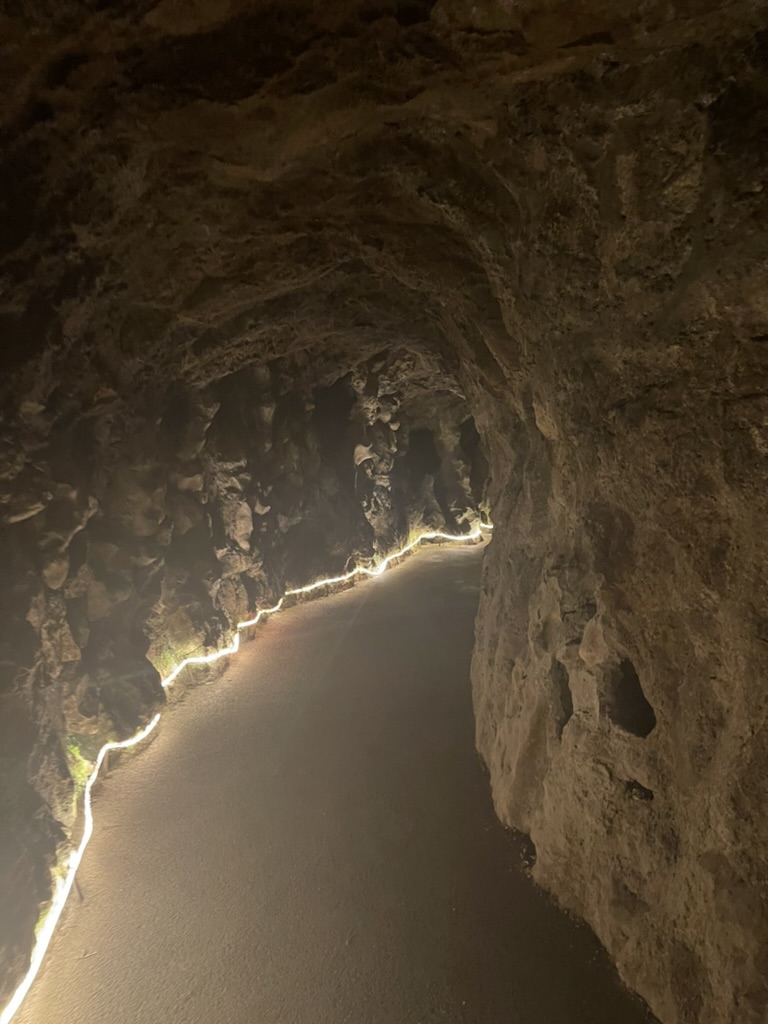A warmly lit tunnel path in Sintra, Portugal, symbolizing movement through darkness toward clarity